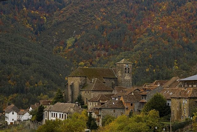 Anvista d'Ansó con a suya ilesia de Sant Per, d'estilo gotico, con as colors d'agüerro en as fuellas d'os arbols