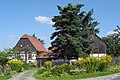 Wohnstallhaus und zwei Seitengebäuden eines Bauernhofes, mit überdachtem Eingang (Hofmauer)