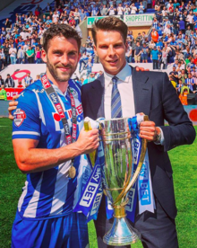 David Sharpe and Will Grigg celebrating Wigan's promotion from League One to the Championship in 2016 David Sharpe and Will Grigg League One Trophy.png