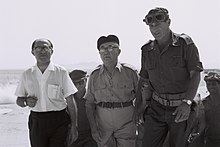 Tři kráčející muži, z toho dva v uniformě