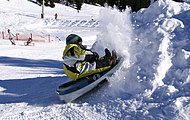 Rodelndes Kind im Skigebiet Laterns-Gapfohl