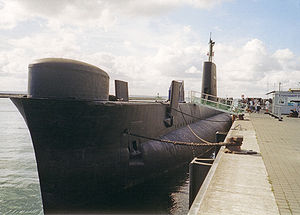 Um submarino amarrado a uma doca.