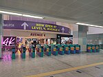 The fare gates to/from the station. The Avenue K shopping mall's concourse level can be seen.