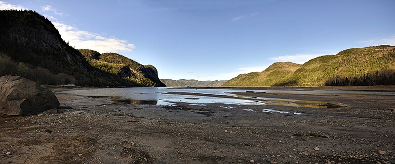 Baie Éternité, Rivière-Éternité'den görülüyor.  Ufukta Saguenay Fiyordu.  Solda, Cape Trinity;  sağda, Cape Eternity.