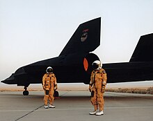 The crew of a NASA Lockheed SR-71 Blackbird standing by the aircraft in their pressurized flight suits, 1991