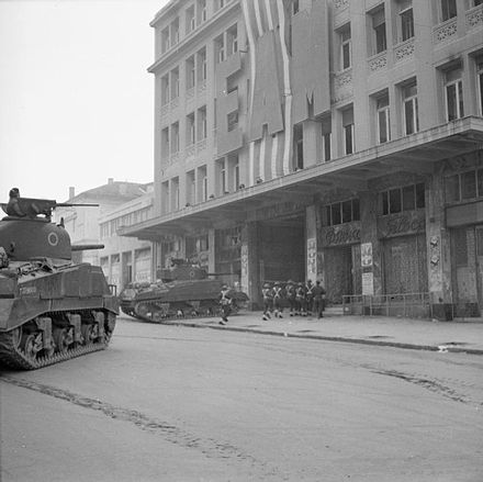British tanks and soldiers outside a building of EAM