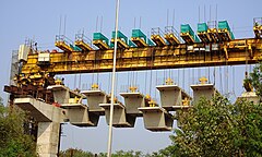 Box girder bridge being built by joining prefabricated segments