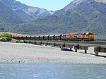 fotó két mozdonyról, amelyek vonatot húznak a hídon