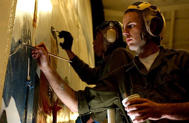 File:US Navy 040708-N-2788L-069 Aviation Boatswain's Mate 3rd Class Joshua Thorpe, right, from Duarte, Calif., and Airman Maurice Dupri, from Chicago, paint a portrait of flight deck personnel on the hangar bay door aboard USS Ronal.jpg