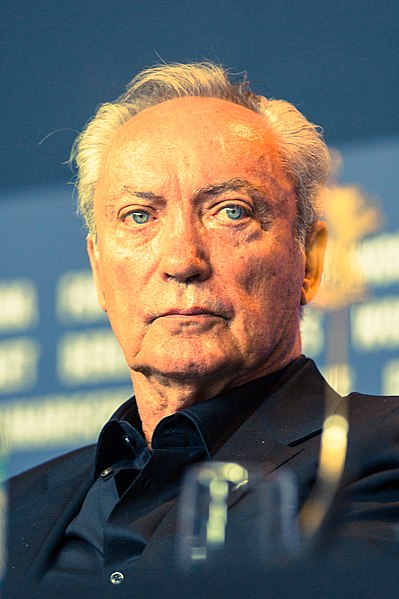 German actor Udo Kier (pictured in 2018) appears in a dual role as the antagonist Åge Krüger, and his infant son Little Brother