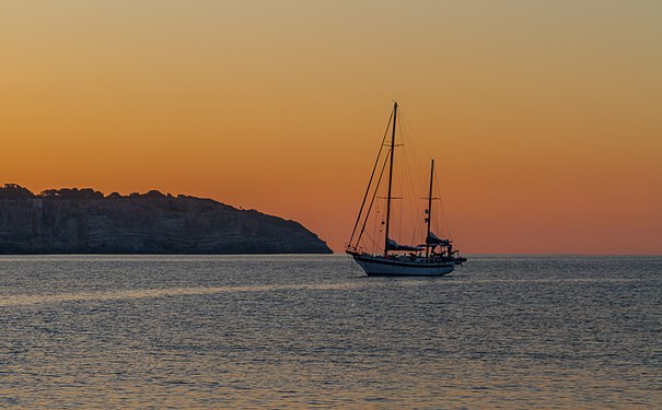 Segelboot bei Sonnenaufgang in der Bucht von Cala Llombards Sailboat at sunrise in the bay of Cala Llombards