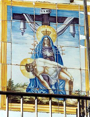 Detalle de plafón cerámico con la representación de la Virgen Dolorosa, sosteniendo a Jesús muerto, en la fachada de una casa de Casas Bajas (Valencia).