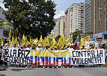 Individuals gathered holding a banner for the "Walk For Peace" march. 18 October 2014 Venezuela protest 1.jpg