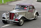 MG TD около 1953 года, с мягким верхом с ручным управлением и съемными боковыми экранами с пластиковыми окнами.