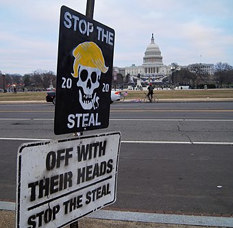 Signs reading "Stop the Steal" and "Off with their heads", photographed on the day of the January 6 attack