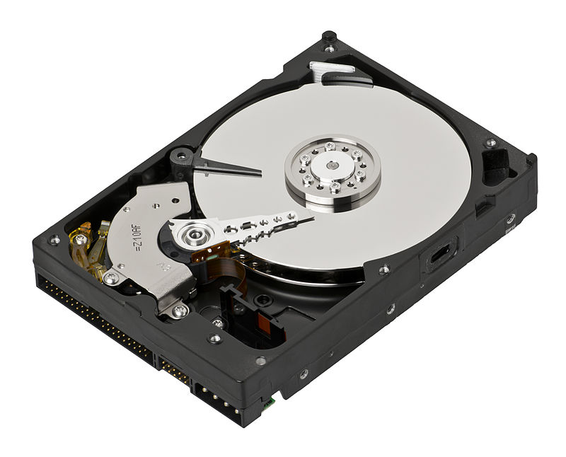 A disassembled harddrive, exposing the read/write arm & the stack of magnetic disks