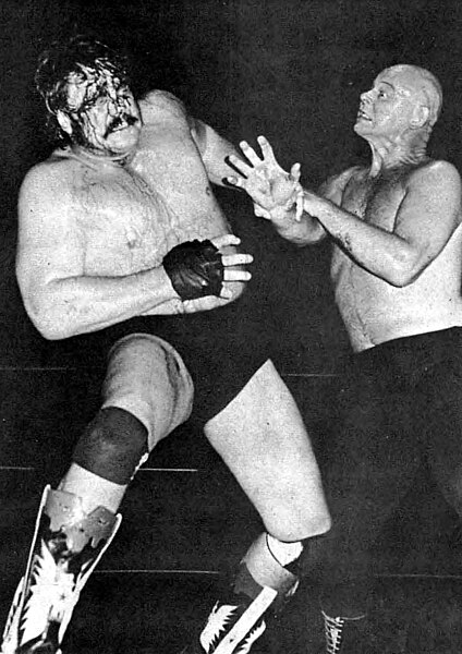 Mulligan (left) blooded during a match against Baron von Raschke (right), circa 1978.