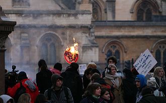 A student protest in London in 2010 Burning 'stop the cuts' Student protests - Parliament Square, London 2010 (5250896975).jpg