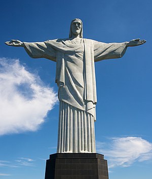 Christ the Redeemer (Portuguese: Cristo Redentor), is a statue of Jesus Christ in Rio de Janeiro, Brazil. The statue stands 39.6 metres (130 feet) tall, weighs 700 tons, and is located at the peak of the 700-m (2296-foot) Corcovado mountain in the Tijuca Forest National Park overlooking the city (source: Commons, Category: Cristo Redentor do Rio de Janeiro)