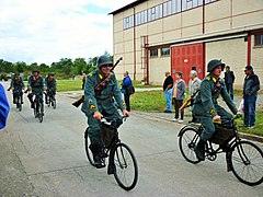 Reconstitution d'une troupe cycliste de 1939 : déplacement avec le fusil en bandoulière par derrière