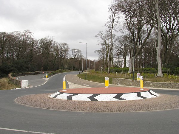 Governor's Bridge newly improved road junction at the A18 Bemahague Road (running uphill into the distance) and the A2 Governor's Road (running left to right) showing the historic section Old Bemahague Road still used as part of TT course gated-off to the left, with the hairpin-bend into the dip just out-of-frame Governors bridgeIMG 0211.JPG