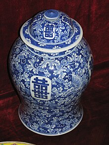 Photographie d'un vase en porcelaine blanche décoré de motifs bleus.