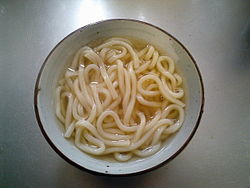 A bowl of plain noodles on a countertop.