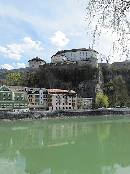 A riverfront inn with the Kufstein fortress in the background