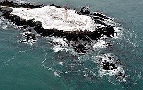 Vue de la pointe Plate enneigée avec son phare.