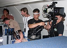 Director Michael Bay (in a white shirt) filming Transformers in an E-3 Sentry in Edwards Air Force Base, United States (2006). Michael Bay at filming of Transformers at Edwards AFB 2006-09-08 1.jpg