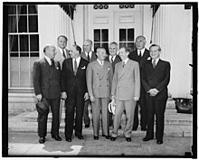 At the White House, Front row, left to right: Barney Balaban, Paramount; Harry Cohn, Columbia Pictures; Nicholas M. Schenck, Loew's; Will H. Hays, and Leo Spitz, RKO. Back row, left to right: Sidney Kent, 20th Century Fox; N.J. Blumberg, Universal; and Albert Warner, Warner Bros., in 1938