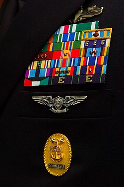 Service ribbons, ribbon devices, and badge awards displayed on a Command Master Chief Petty Officer's service uniform. Navy Ribbons and Badges.jpg