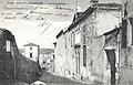 Carte postale noire et blanche d'une rue en enfilade bordée de maisons.
