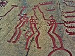 Carvings representing people and boats, painted red