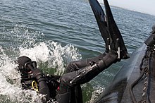 Backward roll entry from a small boat US Navy 110827-N-ZZ999-243 Navy Diver 2nd Class Ryan Kithcens, assigned to Mobile Diving and Salvage Unit (MDSU) 1, dives into San Diego Bay to sea.jpg