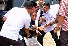 Wiranto (wearing a peci) during the knife attack on 10 October 2019 Wiranto stabbing.jpg