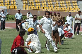 A kho-kho defensive player (centre) runs from one half of the court to the other to avoid being touched by an opponent. A game of Kho-Kho in progress at the Sports meet for Parliamentarians and Media Persons, in New Delhi on August 30, 2005 (1).jpg