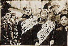 Dvě dívky s transparenty v jidiš a angličtině se sloganem "zrušte dětské otroctví!!"