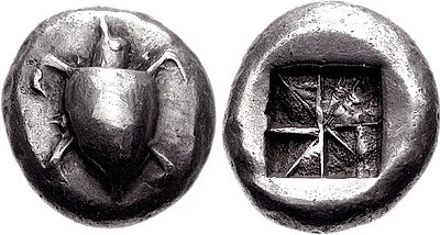 Both sides of a silver coin. One side has a relief of a turtle; the other the impression of a square divided into eight segments.