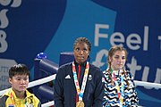 Deutsch: Boxen bei den Olympischen Jugendspielen 2018 Tag 12, 18. Oktober 2018 - Medaillenzeremonie im Leichtgewicht der Mädchen - Gold: Caroline Sara DuBois (Großbritannien), Silber: Porntip Buapa (Thailand), Bronze: Oriana Saputo (Argentinien); Medaillenübergabe durch Habu Gumel (IOC, Nigeria), Geschenkübergabe durch Raymond Silvas (USA, AIBA). English: Boxing at the 2018 Summer Youth Olympics on 18 October 2018 – Girl's Lightweight Medal Ceremony - Gold: Caroline Sara DuBois (Great Britain), Silver: Porntip Buapa (Thailand), Bronze: Oriana Saputo (Argentina); Medal handover by Habu Gumel (IOC, Nigeria), Gift presented by Raymond Silvas (USA, AIBA). Español: Boxeo en los Juegos Olímpicos Juveniles de Verano de 2018 en 18 de octubre de 2018 - Ceremonia de la Medalla de peso ligero para niñas - Oro: Caroline Sara DuBois (Gran Bretaña), Plata: Porntip Buapa (Thailand), Bronce: Oriana Saputo (Argentina); Entrega de medallas por Habu Gumel (COI, Nigeria), Regalo presentado por Raymond Silvas (EE. UU., AIBA).