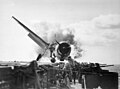 Image 23Crash landing of an F6F Hellcat into the port side 20mm gun gallery of the USS Enterprise, November 10, 1943. Lieutenant Walter L. Chewning, Jr., USNR, the Catapult Officer, is climbing up the plane's side to assist the pilot from the burning aircraft. The pilot, Ensign Byron M. Johnson, escaped without significant injury. Note the plane's ruptured belly fuel tank.