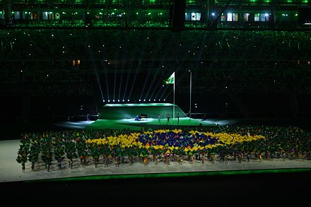 A group forms the flag of Brazil during the Brazilian national anthem at the opening ceremony.
