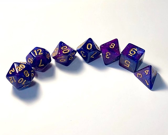 D&D uses polyhedral dice to resolve in-game events. These are abbreviated by a 'd' followed by the number of sides. Shown from left to right are a d20