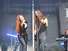 deux membres d'un groupe chantent dans des micros sur scène