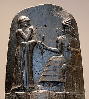 Hammurabi (left), depicted as receiving his royal insignia from Shamash (or possibly Marduk). Hammurabi holds his hands over his mouth as a sign of prayer (relief on the upper part of the stele of Hammurabi's code of laws).