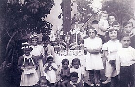 Fête Dieu devant la croix hosannière à l'entrée de la maison Pouzadé en 1945