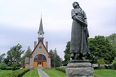 Staty med Longfellows Evangeline (av Louis-Philippe Hébert) och minneskyrkan.