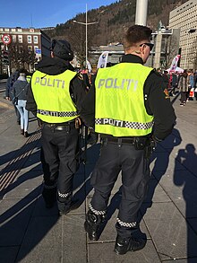 Norwegian police uniforms with black and white Sillitoe tartan chequered markings Norwegian police officers with high-visibility uniform vests (utrykningspolitiet holder vakt under folkearrangement) in Christies gate in Bergen, Norway 2018-03-17 a.jpg
