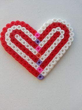 A red and white heart made of Perler or fusion beads (beaded side up).