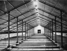 Cast iron frame in Watervliet Arsenal building 40 (c. 1840) Photograph of a photograph in possession of the Watervliet Arsenal Museum, New York. CONSTRUCTION PHOTOGRAPH SHOWING CAST IRON TRUSS SYSTEM IN WHAT IS PROBABLY UNIT 2. TAKEN IN 1865. - Watervliet Arsenal, Building No. 40, cropped.tif